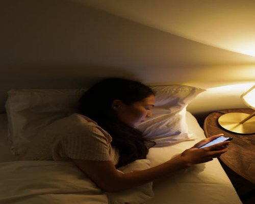 Browsing phone in bed with lights off